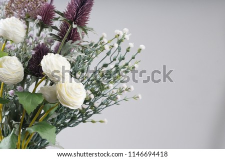Woman hand holding bouquet of fresh flowers on light background.
