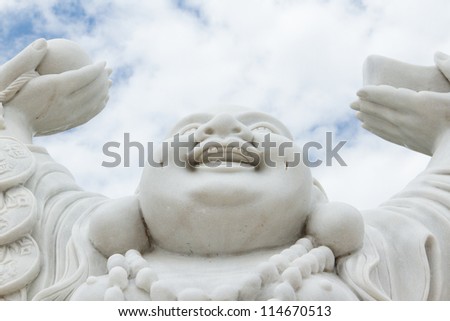 Laughing Buddha isolated against the bright sky