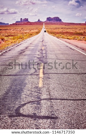 Scenic road to Monument Valley, color toned picture, focus on asphalt, USA.