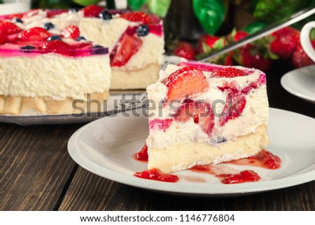 Portion of cheesecake with strawberries, blueberry and jelly on a plate