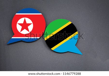 North Korea and Tanzania flags with two speech bubbles on dark gray background