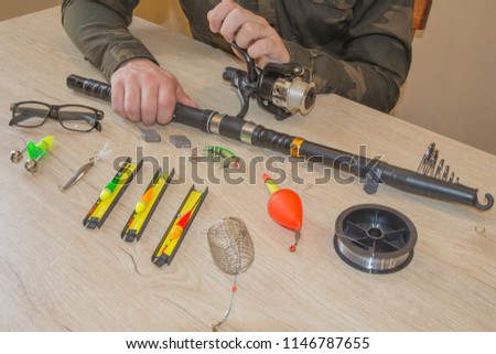 Close-up of a fisherman's hands with Fishing tackle.  Items include fishing reel, hooks, floats