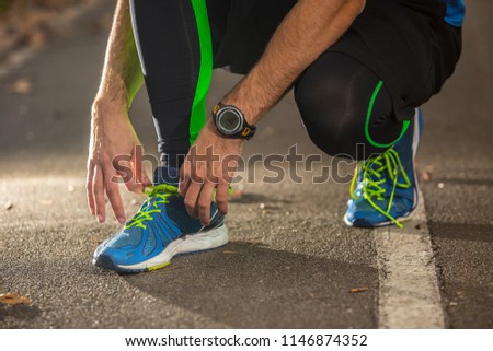 Ready to go! low angle photo of shoe of male athlete on the tarmac, preparing for a run. autumn  morning
