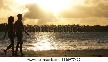 a couple on the beach with sunset