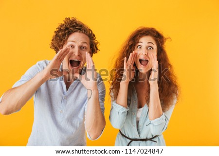 Image of happy friends loving couple standing isolated over yellow background screaming looking camera.
