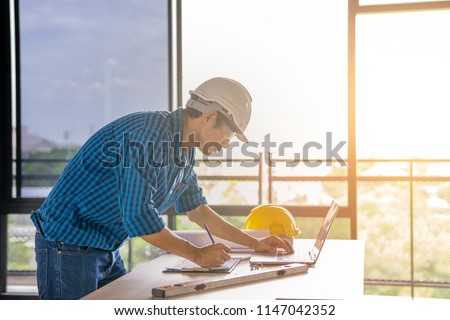 civil architech engineer choose color of building with laptop,engineering and architecture concept.Blue print is fake only for stock photo.