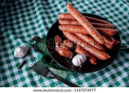Chinese Sausages in black dish (plate) decorate with 
spices on checker fabric