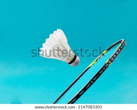 Close up shuttlecock and badminton racket on blue background. Royalty-Free Stock Photo #1147083305