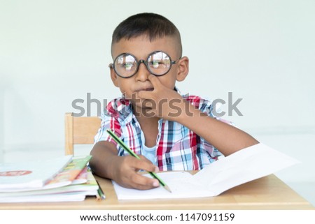 Cute asian little boy writing a book
