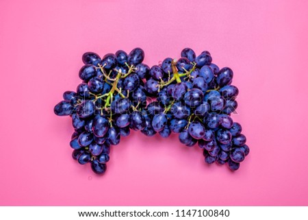Natural organic black juicy grapes on a trend pink background  Top View Flat Lay. Rustic Style. Country Village Agriculture concepts 