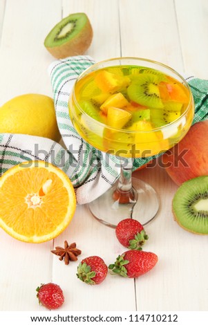 punch in glass with fruits, on white wooden table