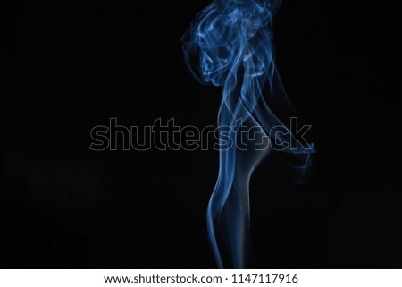 Blue swirling smoke abstract close up on black background