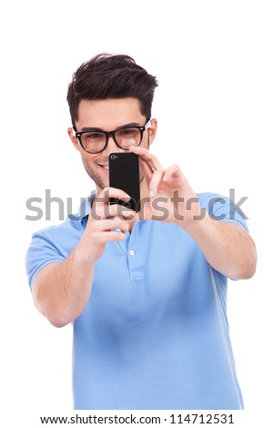 young smiling casual man taking a picture of you with his phone. isolated on white background