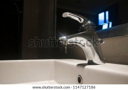 Water drop from faucet with slow shutter speed in luxury and modern bathroom