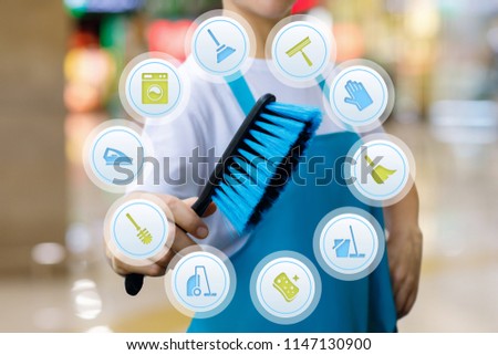 Worker with brush in hand provides cleaning services on blurred background.