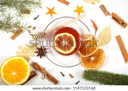 mulled wine hot drink on a bright background next to lie fruit and spices
