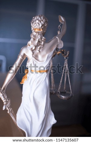 Law office legal justice statue of blind goddess Themis with scales in lawyers office.