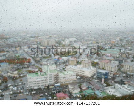 Abstract Background : Window full of rain water, blurred city in background.