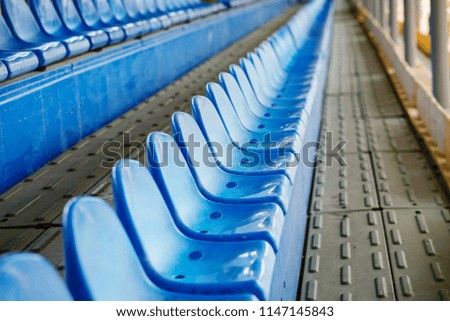 Empty plastic chairs in the stands of the stadium.
