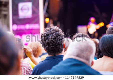 Group of people attending to live music concert and blurry color lights