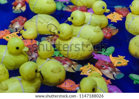 Yellow toy rubber duck family floats in the water.
