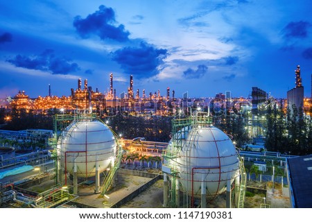 Gas storage sphere tanks and pipeline in oil and gas refinery industrial plant with glitter lighting industry estate at twilight Royalty-Free Stock Photo #1147190381