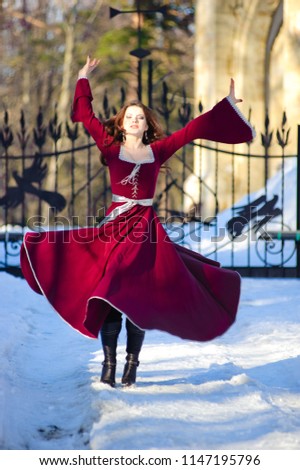 girl in a medieval dress whirl dancing on the snow