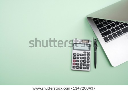 Flat lay, top view office table desk. Workspace with calculator,pen,laptop on the indigo green background.Copy Space for text,Empty Blank to word.Business Finance,Education Technology.Work from home. Royalty-Free Stock Photo #1147200437