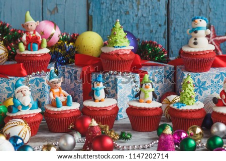 Christmas cupcakes with colored decorations made from confectionery mastic, soft focus background