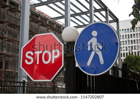 Close up photo of blue traffic sign "Footpath" and red sign "Stop". 