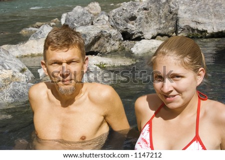 father and daughter enjoying a hot rock pool - lussier hot springs, located in the whiteswan provincial park, BC, Canada