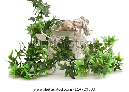 Isolated still life decor with toy rabbit, cart and plant