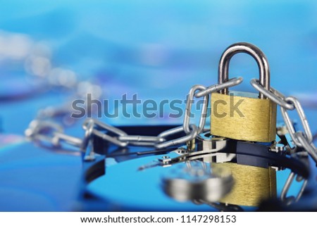 Data security, information protection and personal information defense. Padlock on hard drive disk at CD disk background. Concept of digital data and information defense, antivirus PC protection.