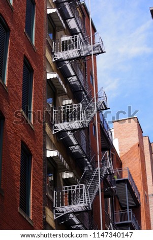 Fire escape stairs-downtown back alley architecture-steel and red brick background