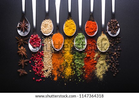 Spices and condiments for cooking on a black background Royalty-Free Stock Photo #1147364318