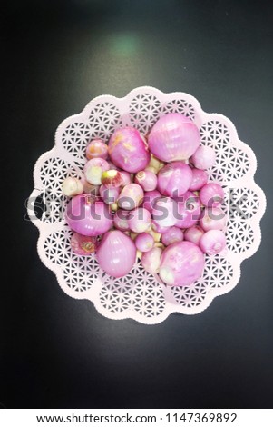 A top down picture of red onions and garlic in a basket used in the kitchen for cooking. Raw onions have higher levels of organic sulfur compounds that provide many benefits