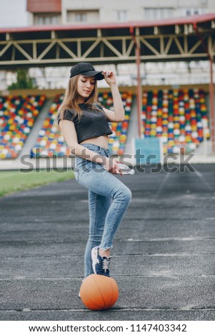 girl standing with a basketball at the stadium