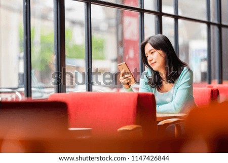 Asian beautiful woman with smartphone in coffee shop.