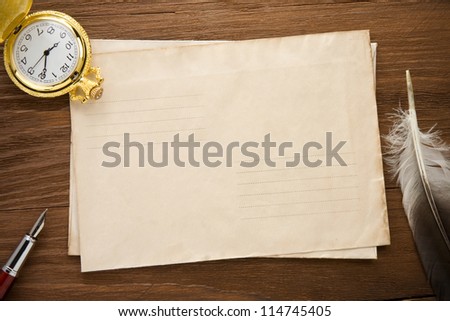 watch and ink pen at envelope on vintage wood background texture