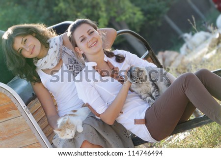young happy smiling women with cats on natural background