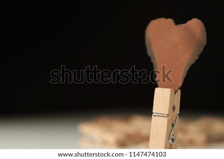 Old vintage wooden cloth pin over isolated white background. burn love card.