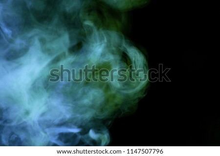 Colorful green and blue smoke  on a black isolated background. Background from the smoke of vape
