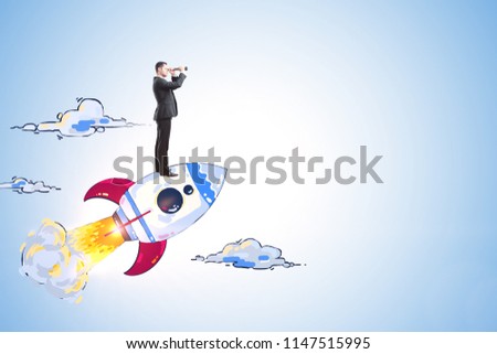 Businessman with binoculars looking into the distance on creative launching rocket sketch on blue wall background. Startup and research concept