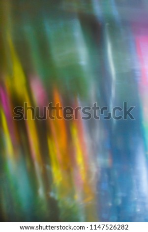 Artistic closeup through a car windshield of bokeh street lights at night, creating pattern with rain texture, and a fairy painting colorful atmosphere, Paris, France.