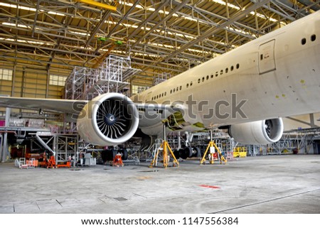 Side view of aircraft (airplane)engine during lift up from the floor by aircraft jack for maintenance at aircraft hangar.Aircraft on jack in hangar for maintenance service check by mechanic. Royalty-Free Stock Photo #1147556384