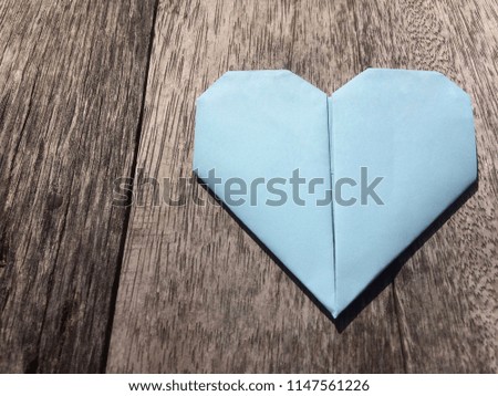 Blue paper folded origami love heart on wooden background for card Mother 's day