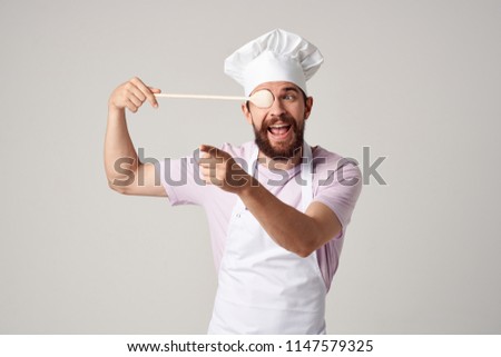   Joyful chef with a wooden spoon.                             