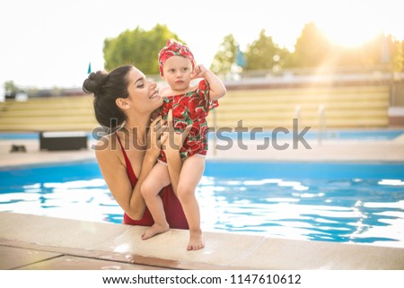 Lovely mother hugging her baby in the swimmingpool