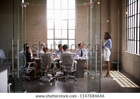 Businesswoman presenting to colleagues at boardroom meeting Royalty-Free Stock Photo #1147684646