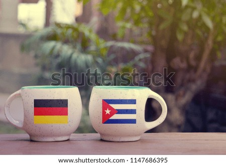 Germany and Cuba Flag on two tea cups with blurry background